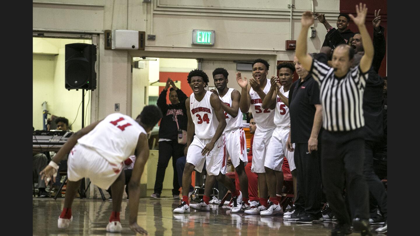 Westchester players jump elatedly from the bench as teammate Luis Rodriguez (11) hits a three pointer midway through the fourth quarter to pull the Comets within three points of the Lions at Westchester High School.