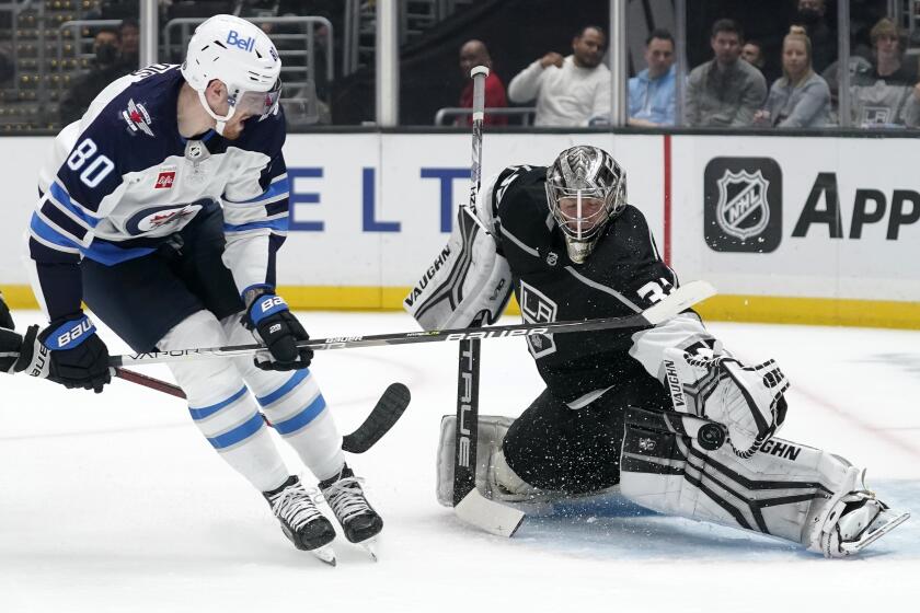 Los Angeles Kings goaltender Jonathan Quick, right, makes a glove save on a shot by Winnipeg Jets left wing Pierre-Luc Dubois during the first period of an NHL hockey game Thursday, Oct. 27, 2022, in Los Angeles. (AP Photo/Mark J. Terrill)