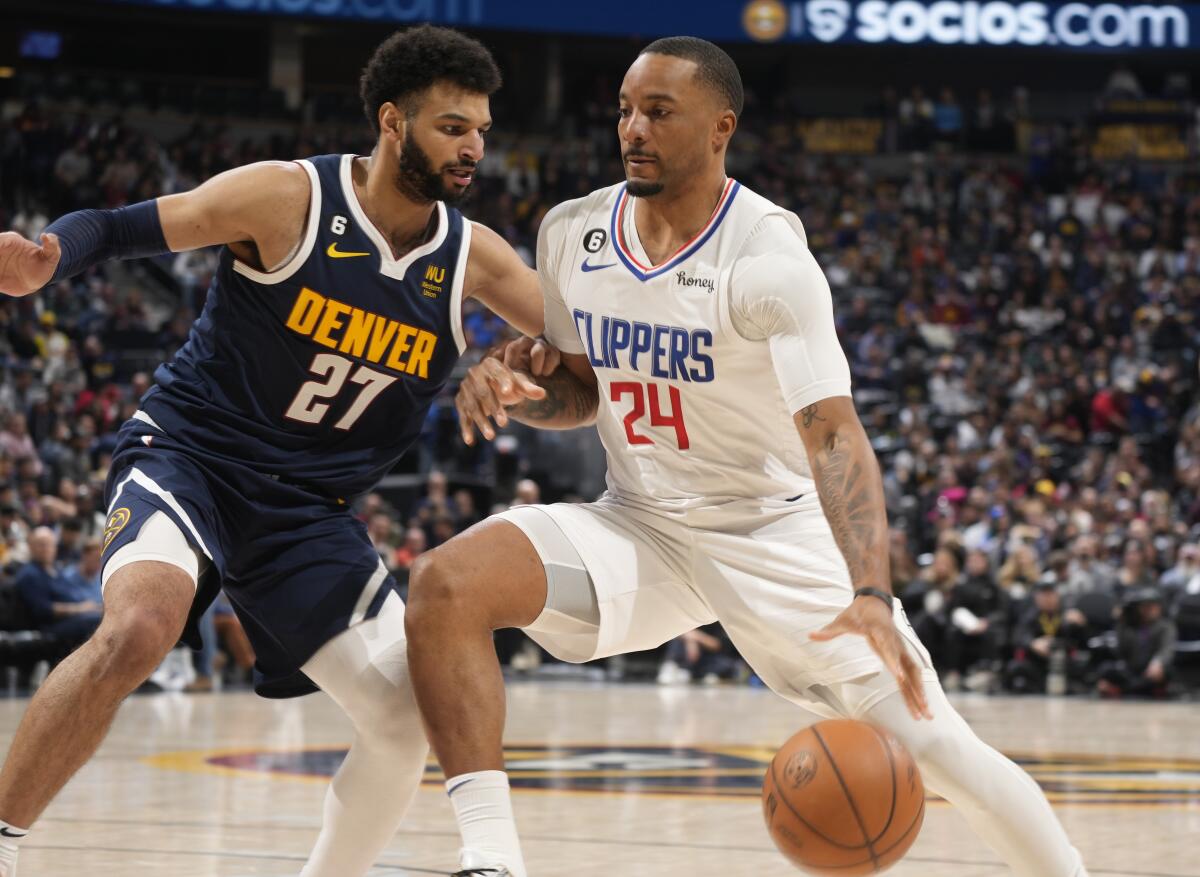 Clippers forward Norman Powell drives as Denver Nuggets guard Jamal Murray defends.