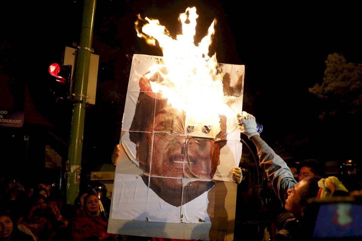 Manifestantes queman un cartel con el rostro de Evo Morales, ex presidente de Bolivia.