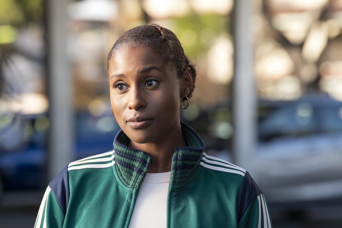 A woman in a green track suit looks into the distance