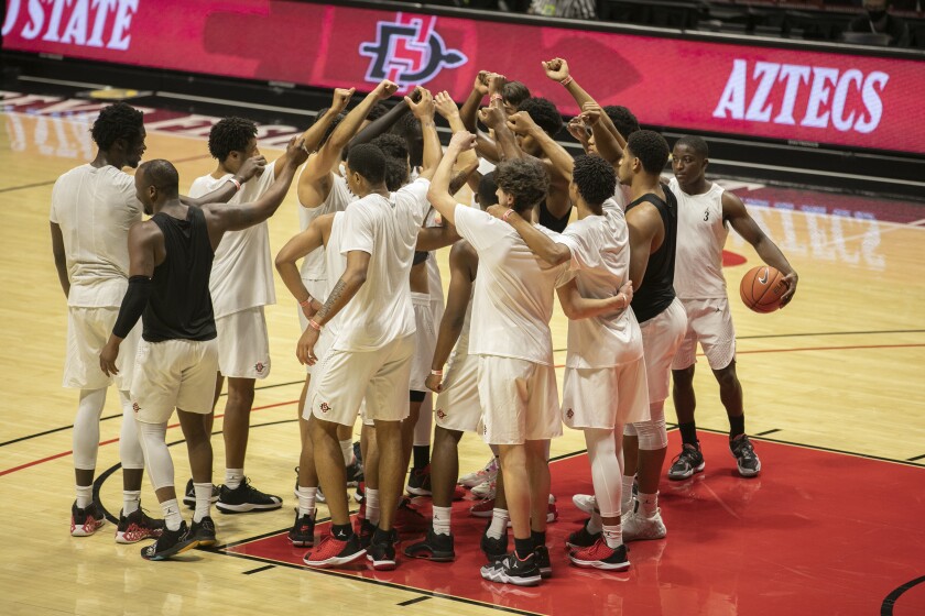 Aztecs players gather together before the start of their basketball game against BYU.
