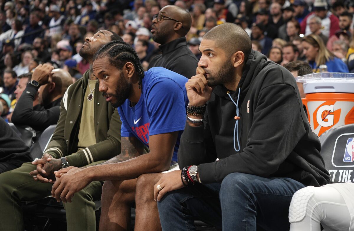 From left, the Clippers' John Wall, Kawhi Leonard and Nicolas Batum watch the team's loss at Denver on Jan. 5, 2023.