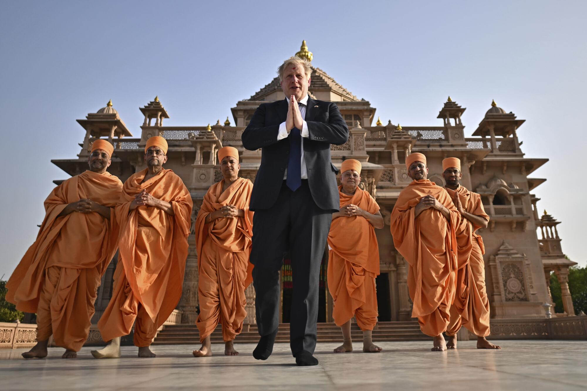 Britain's Prime Minister Boris Johnson, center, poses with Sadhus, or Hindu holy men
