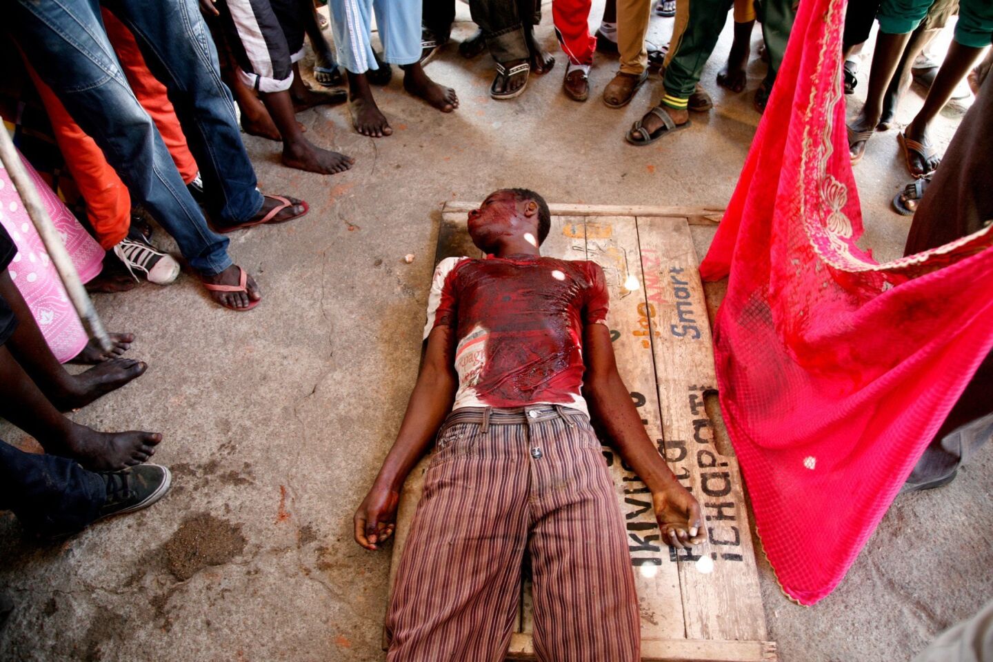 Protesters stand next to the body of a man who died May 12 in clashes with police in Burundi's capital, Bujumbura.