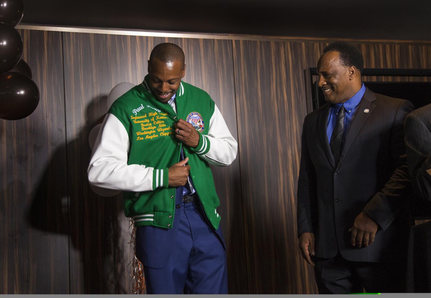 Clipper and Inglewood native Paul Pierce admires the letterman's jacket given to him by Inglewood Mayor James Butts during an event welcoming Pierce back on July 30, 2015 at The Forum in Inglewood, California.