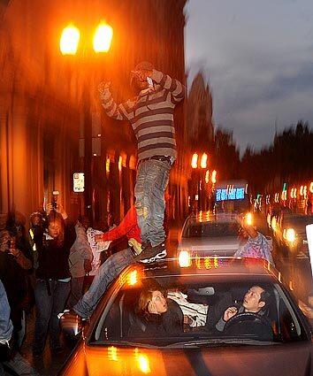 Demonstrators jump on a car in Oakland on Friday after former police officer Johannes Mehserle was sentenced to two years in prison. A peaceful demonstration at City Hall in reaction to the sentencing later turned aggressive.