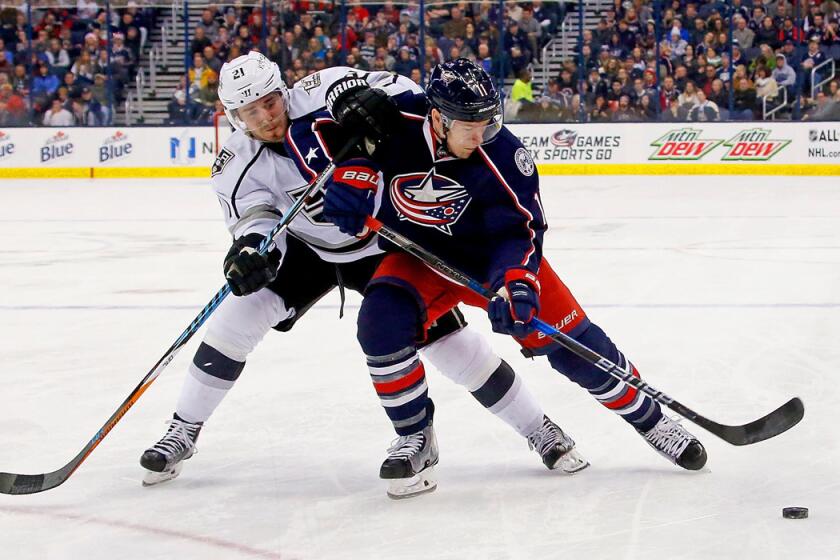 Columbus Blue Jackets' Matt Calvert (11) and Kings' Nick Shore (21) battle for control of the puck during the second period on Tuesday.