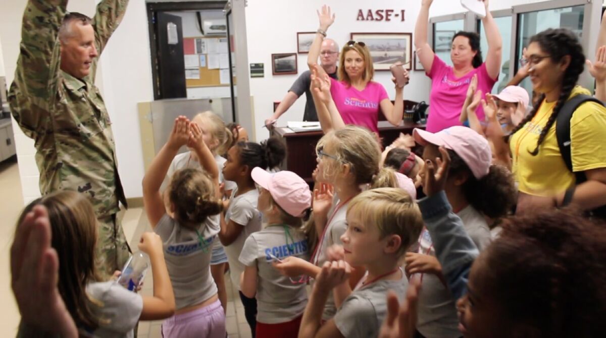 Project Scientist participants raise their hands during an "expedition" to see Black Hawk and Chinook helicopters last summer in St. Paul, Minn. The organization works with girls ages 4 to 12 who are interested in science, technology, engineering and math.