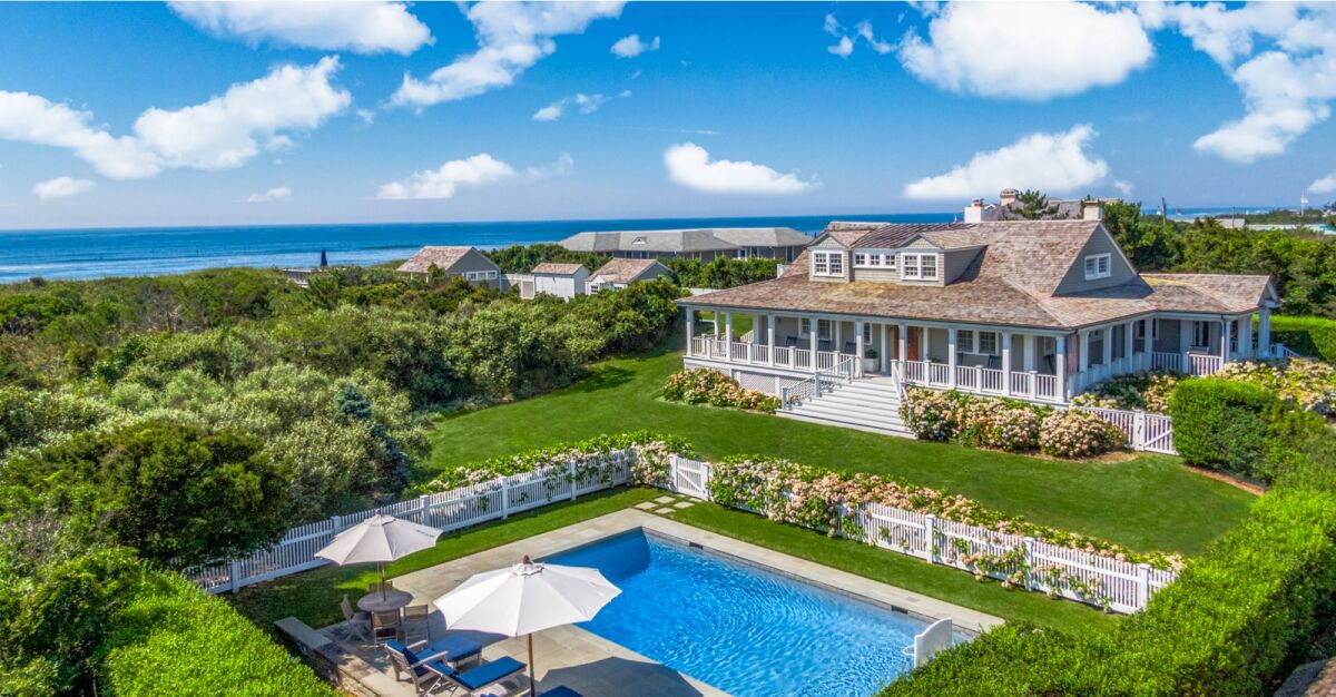 The 1.1-acre estate includes a wood-clad home, detached bungalow, heated pool.