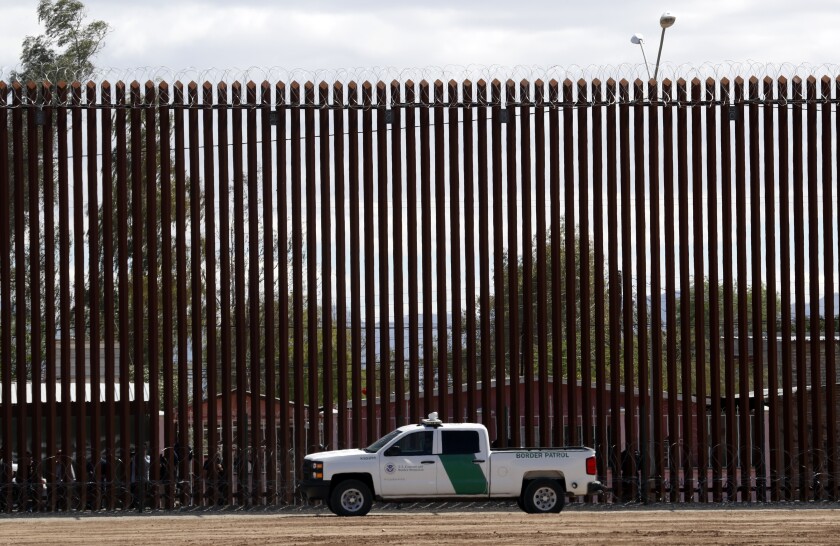 U.S. Customs and Border Protection vehicle sits near the wall