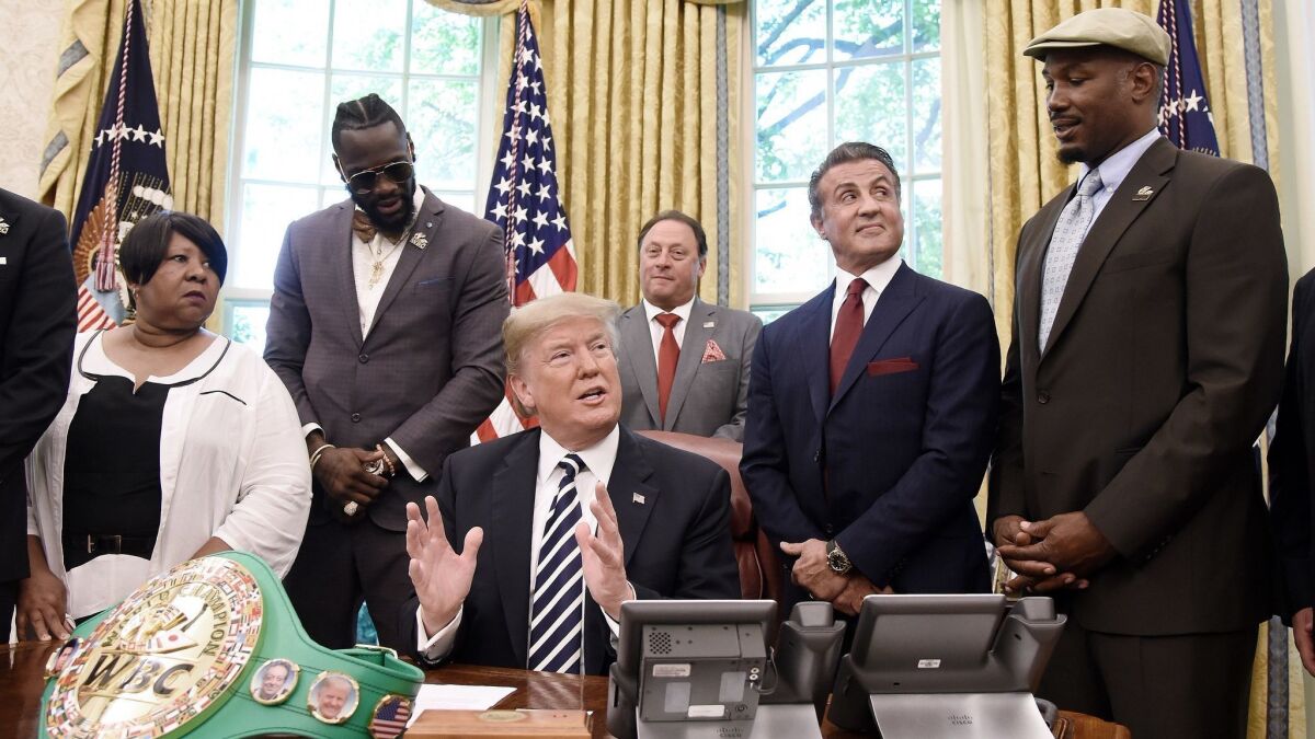 President Trump with Linda Haywood, left, Jack Johnson's great-great niece, Deontay Wilder, Keith Frankel, Sylvester Stallone and Lennox Lewis in the Oval Office after signing Johnson's pardon.