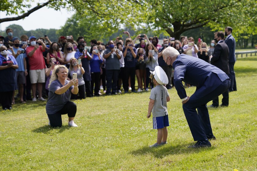 President Biden poses for a photo with a child