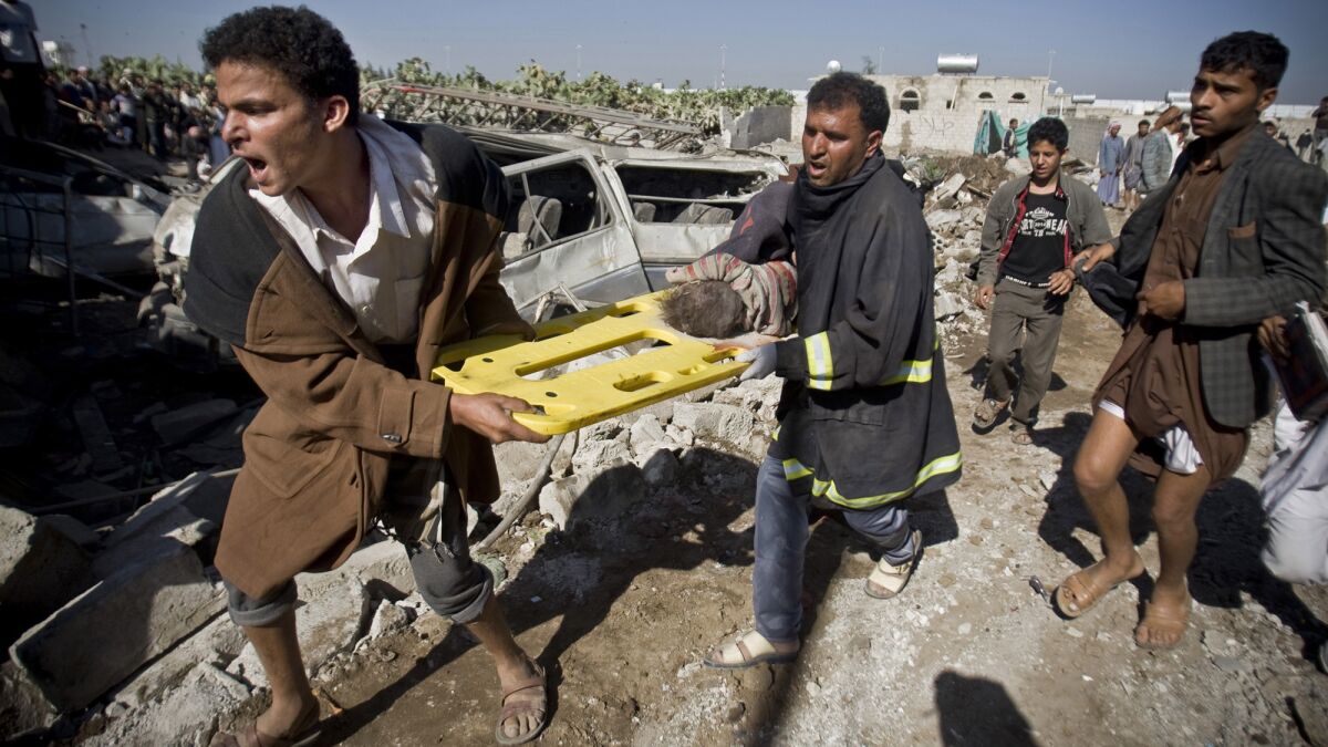 Men carry the body of a child uncovered from the rubble of houses destroyed by Saudi airstrikes near Sana's international airport in Yemen on March 26.