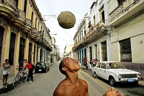 Luis Fernando Monzon Zantana plays soccer in a Havana street. Though Cuba's economy is booming, its buildings and infrastructure are falling apart.