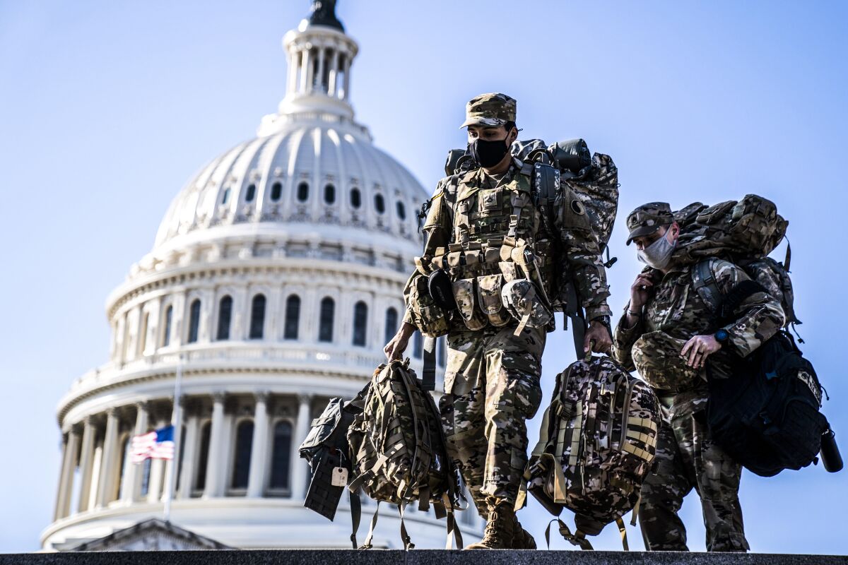 Members of the National Guard carry supplies near the U.S. Capitol.
