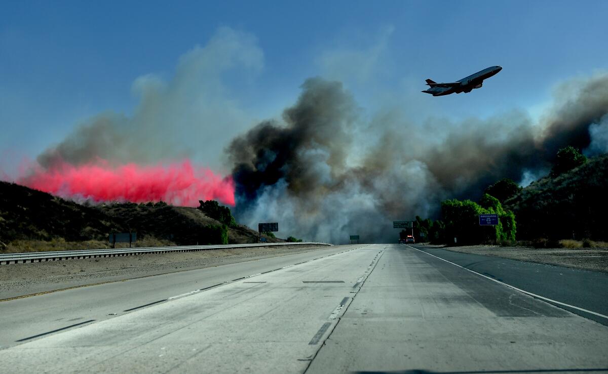 An air tanker drops fire retardant near the 23 Freeway as firefighters make a stand and prevent the Easy Fire from burning into Moorpark Wednesday. 