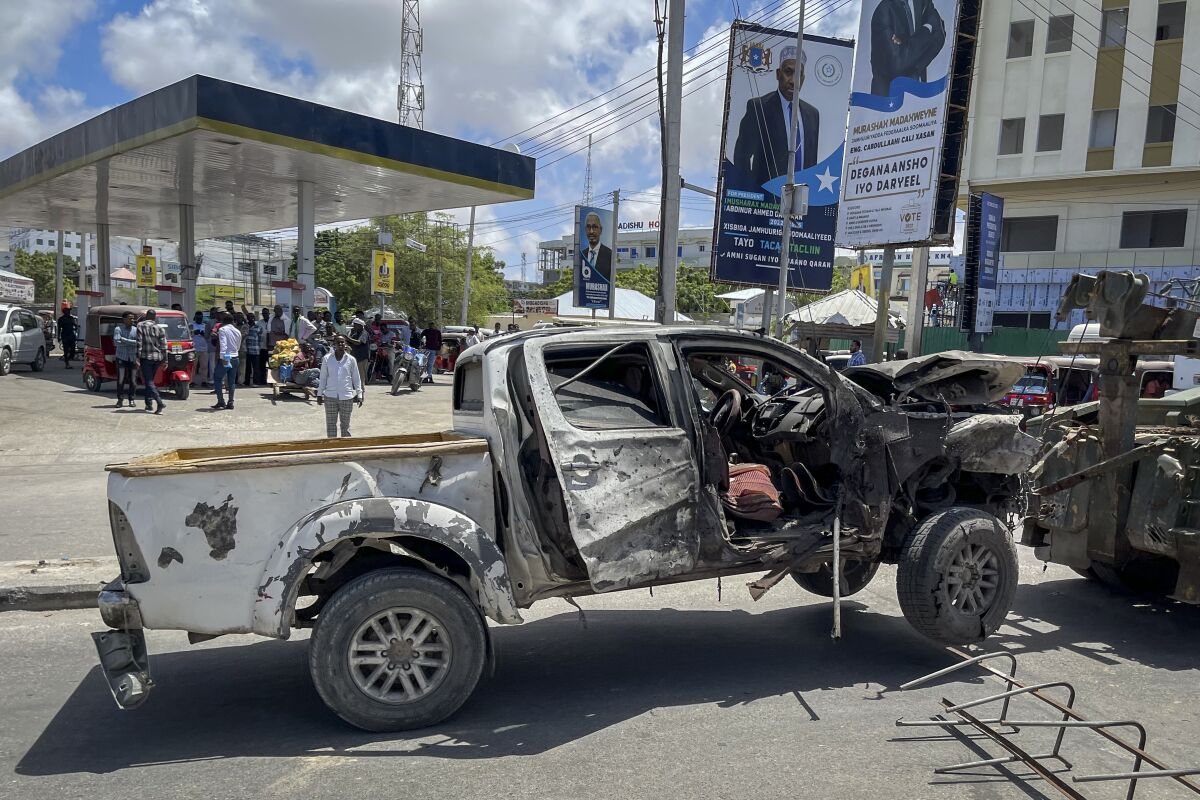 A destroyed vehicle is removed from the scene after a suicide bomb attack at a checkpoint near the airport in Mogadishu, Somalia, Wednesday, May 11, 2022. Somali police say several people have been killed in the explosion which happened as presidential candidates were heading into the heavily fortified airport area to address lawmakers ahead of Sunday's vote for president. (AP Photo/Farah Abdi Warsameh)