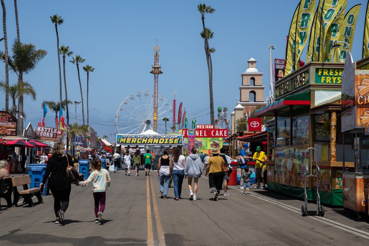 Attendees walk down the Avenue of the Palms on opening day at the San Diego County Fair in Del Mar on Wednesday.