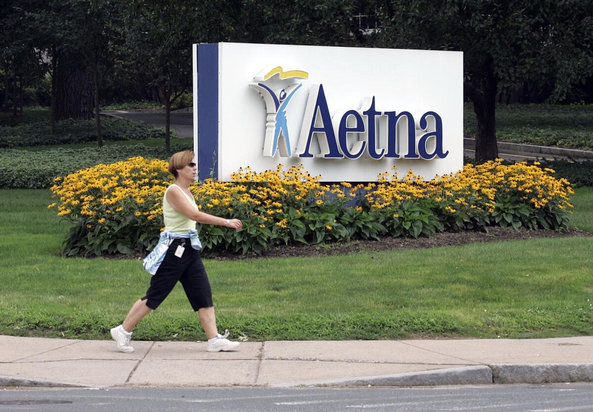 A woman passes the Hartford, Conn., headquarters of Aetna