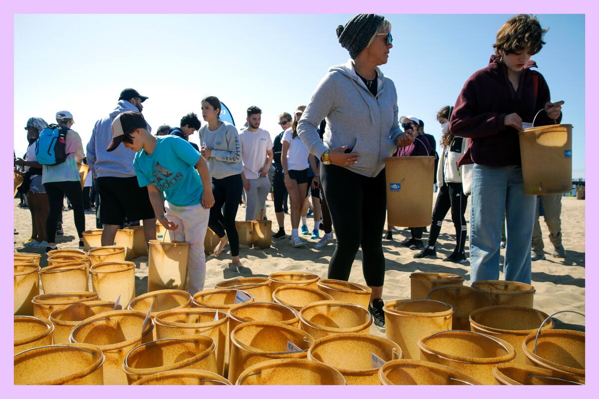 Volunteers collect buckets to take part in Nothin' But Sand Cleanup organized by Heal the Bay at Santa Monica, CA.