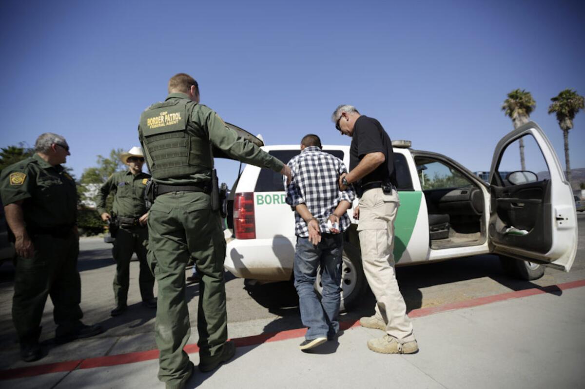 Agentes de la Border Patrolse llevan a una persona indocumentada en San Diego, California.
