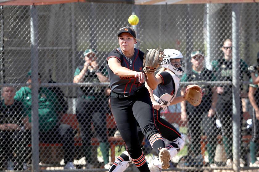 Saige Anderson (47) of Huntington Beach throws to first for an out to end the inning.