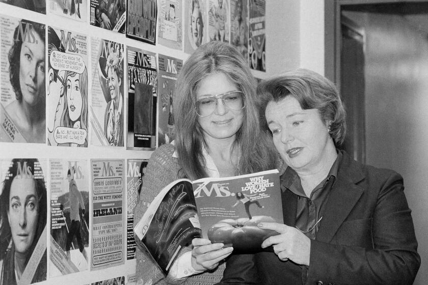 Gloria Steinem, left, and Pat Carbine, two of Ms. magazine's founding editors, look through a copy of the magazine at Ms. offices on Jan. 29, 1980.