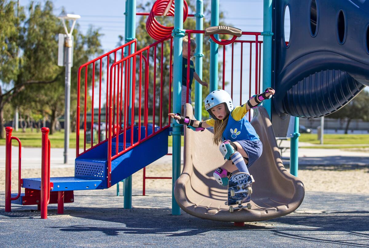 Brooke Benton, 6, rides down a slide at Edison Park Skate Spot on Wednesday.