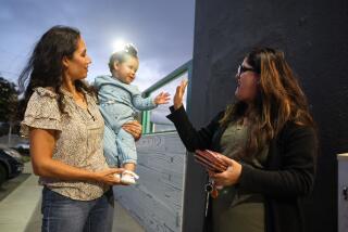 Salinas, CA - September 27: Doctor Nadia Arias with her baby Mia, left, visits with Dr. Olga Padron, right, during a social gathering after work on Wednesday, Sept. 27, 2023 in Salinas, CA. Many of the doctors who are participating in a unique program that brings Mexican doctors to work at Federally Qualified Health Centers in California, gather bi-monthly. (Dania Maxwell / Los Angeles Times)