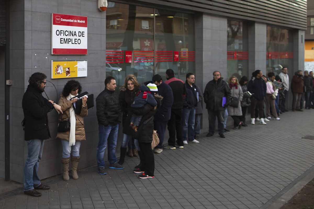 People wait in line outside an unemployment registry office in Madrid on Thursday. Spain's unemployment rate remained stuck at 26% in the fourth quarter as the economy expanded but not enough to trigger job growth, according to a pair of government reports issued Thursday.
