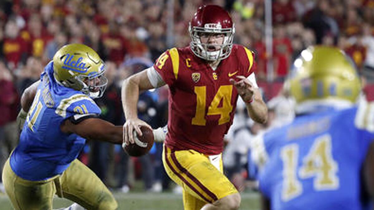 USC quarterback Sam Darnold scrambles out of the pocket and away from UCLA defensive lineman Jacob Tuioti-Mariner in the closing seconds of the second quarter on Nov. 18.