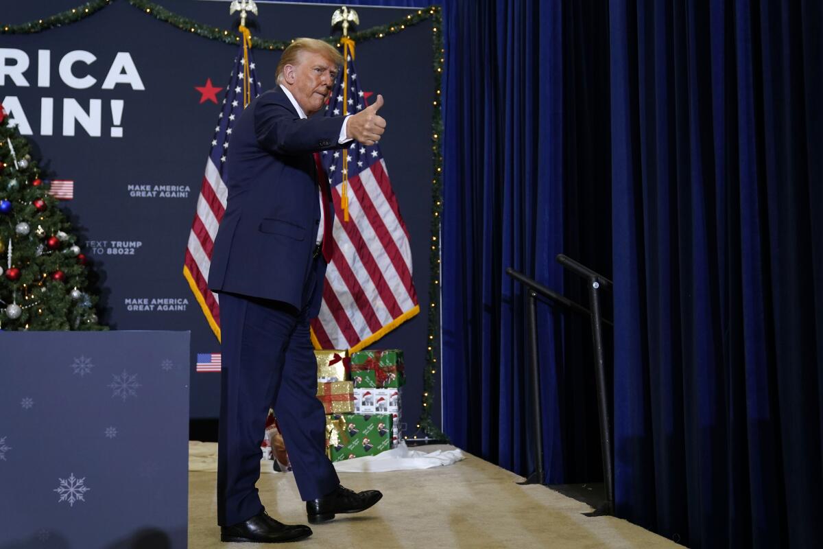 Former President Trump gives a thumbs up and walks off stage after speaking at a rally.