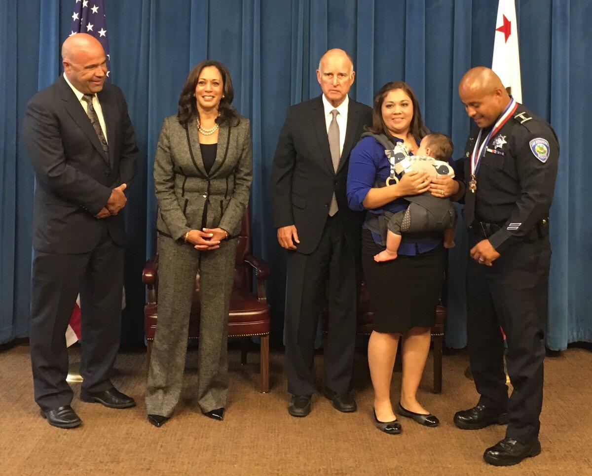 San Bernardino police Officer Brian Olvera, posing with his family, was one of eight officers awarded the Medal of Valor by Gov. Jerry Brown, center, and Atty. Gen. Kamala Harris, second from left.