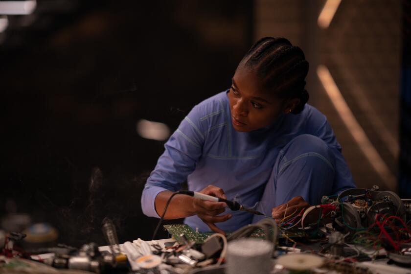 a young woman soldering pieces of equipment 