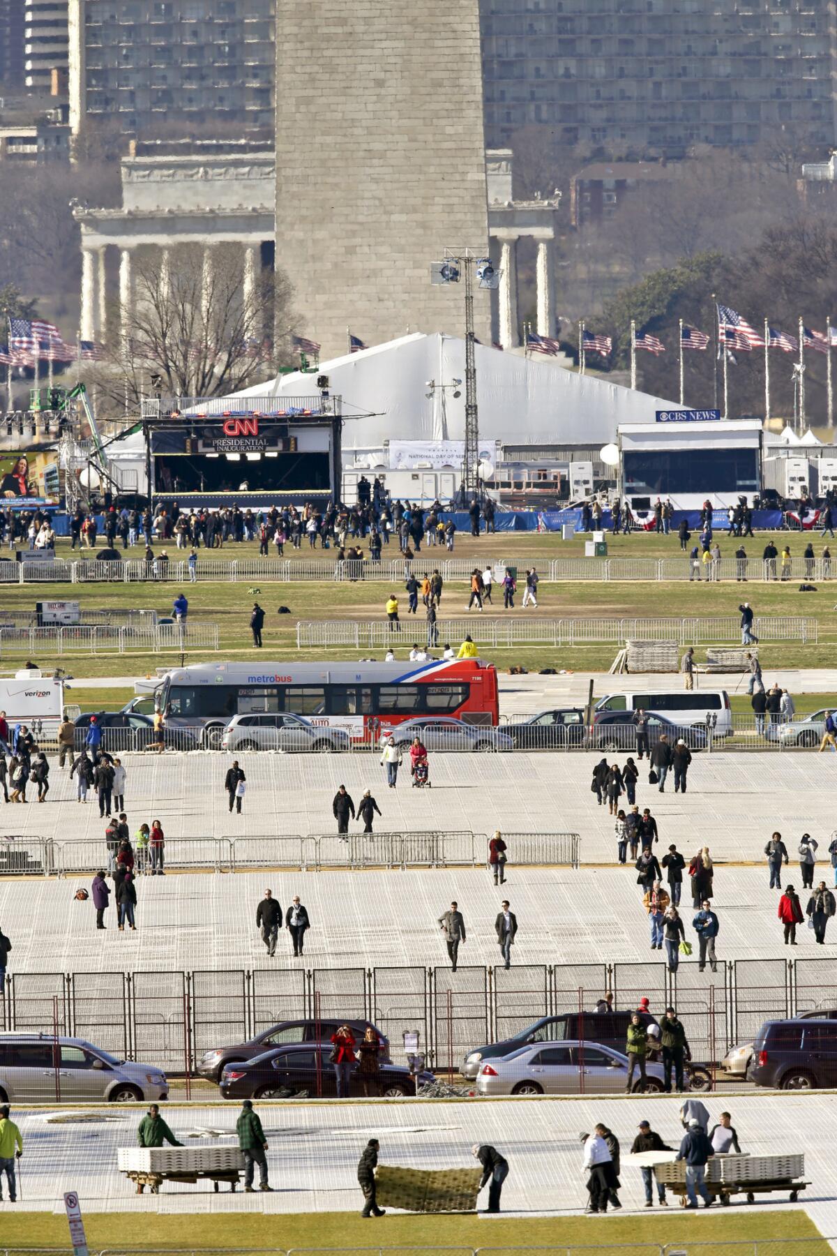 Crews lay down mats to protect the lawn on the National Mall before President Obama's second inauguration in 2013. (J. Scott Applewhite / AP)