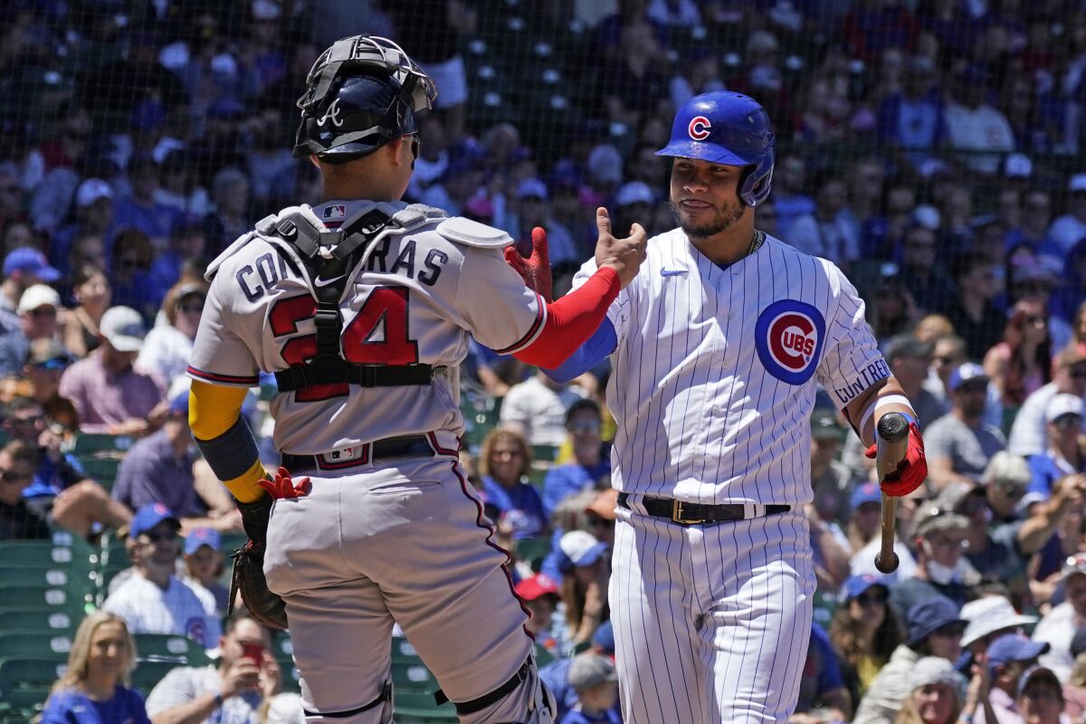Chicago Cubs' Willson Contreras, right, greets his brother Atlanta Braves catcher William Contreras during the first inning of a baseball game in Chicago, Saturday, June 18, 2022. (AP Photo/Nam Y. Huh)