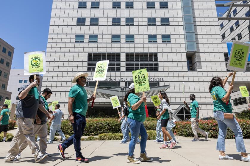 WESTWOOD, CA - JULY 31: Members of American Federation of State, County and Municipal Employees (AFSCME) 3299 with support from other labor unions picket in front of Ronald Reagan UCLA Medical Center in Westwood, CA on Wednesday, July 31, 2024. AFSCME has been negotiating their contract for six months but the union says they are at an impasse. Liz Perlman, executive director of AFSCME 3299 said they are seeking wages to keep up with the cost of living, save staffing protections and address the housing crisis by divesting from Blackstone and investing in affordable housing for workers and students. (Myung J. Chun / Los Angeles Times)