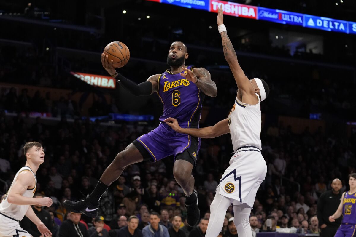 Lakers star LeBron James puts up a shot over Denver Nuggets forward Bruce Brown in the first half Friday.