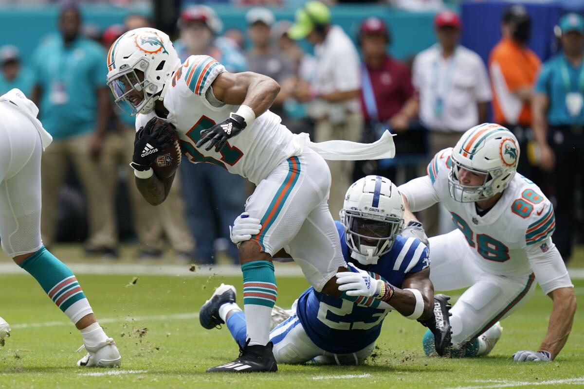 Miami Dolphins running back Myles Gaskin (37) gets tackled by Indianapolis Colts cornerback Kenny Moore II (23), as Miami Dolphins tight end Mike Gesicki (88) gives chase, during the first half of an NFL football game, Sunday, Oct. 3, 2021, in Miami Gardens, Fla. (AP Photo/Lynne Sladky)