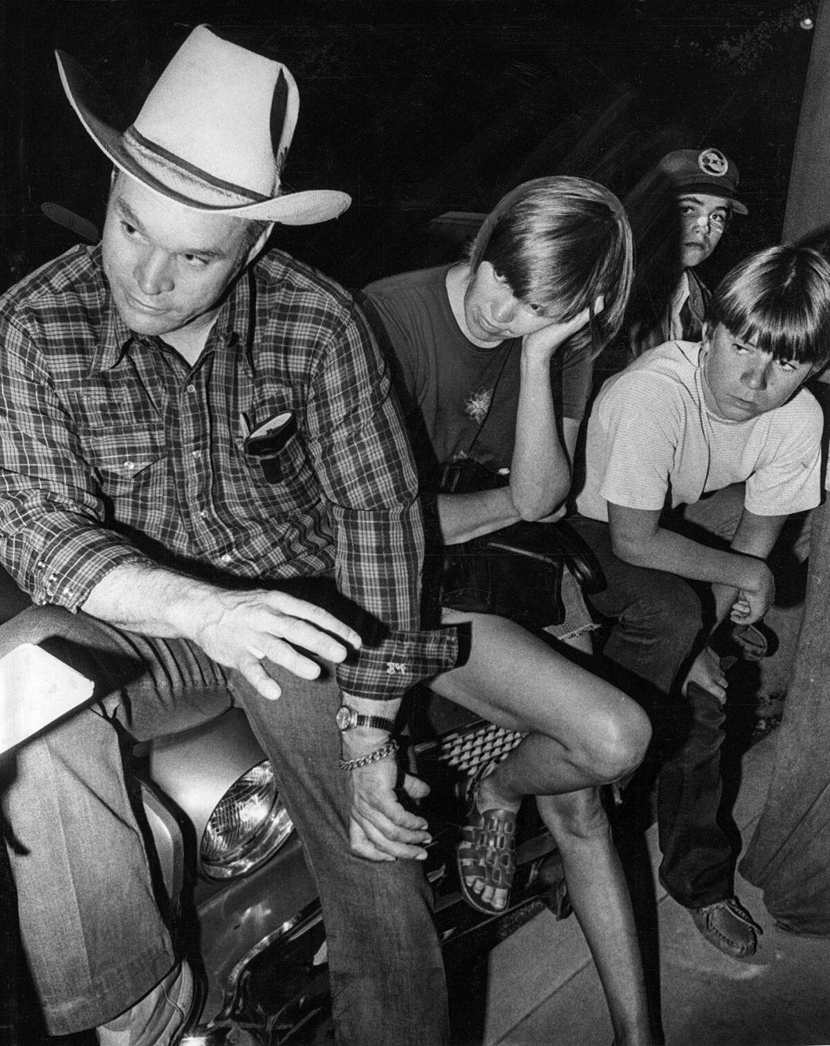 July 17, 1976: Bob, left, and Carol Marshall talk to a reporter while waiting at command post for return of their son Mike and other kidnap victims. Boys on right were not identified.