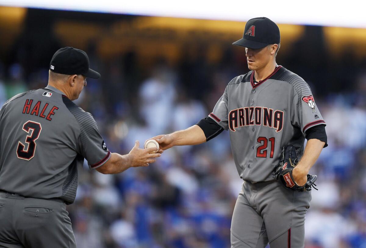 Diamondbacks starting pitcher Zack Greinke, right, is taken out of the game by Manager Chip Hale during the fifth inning.