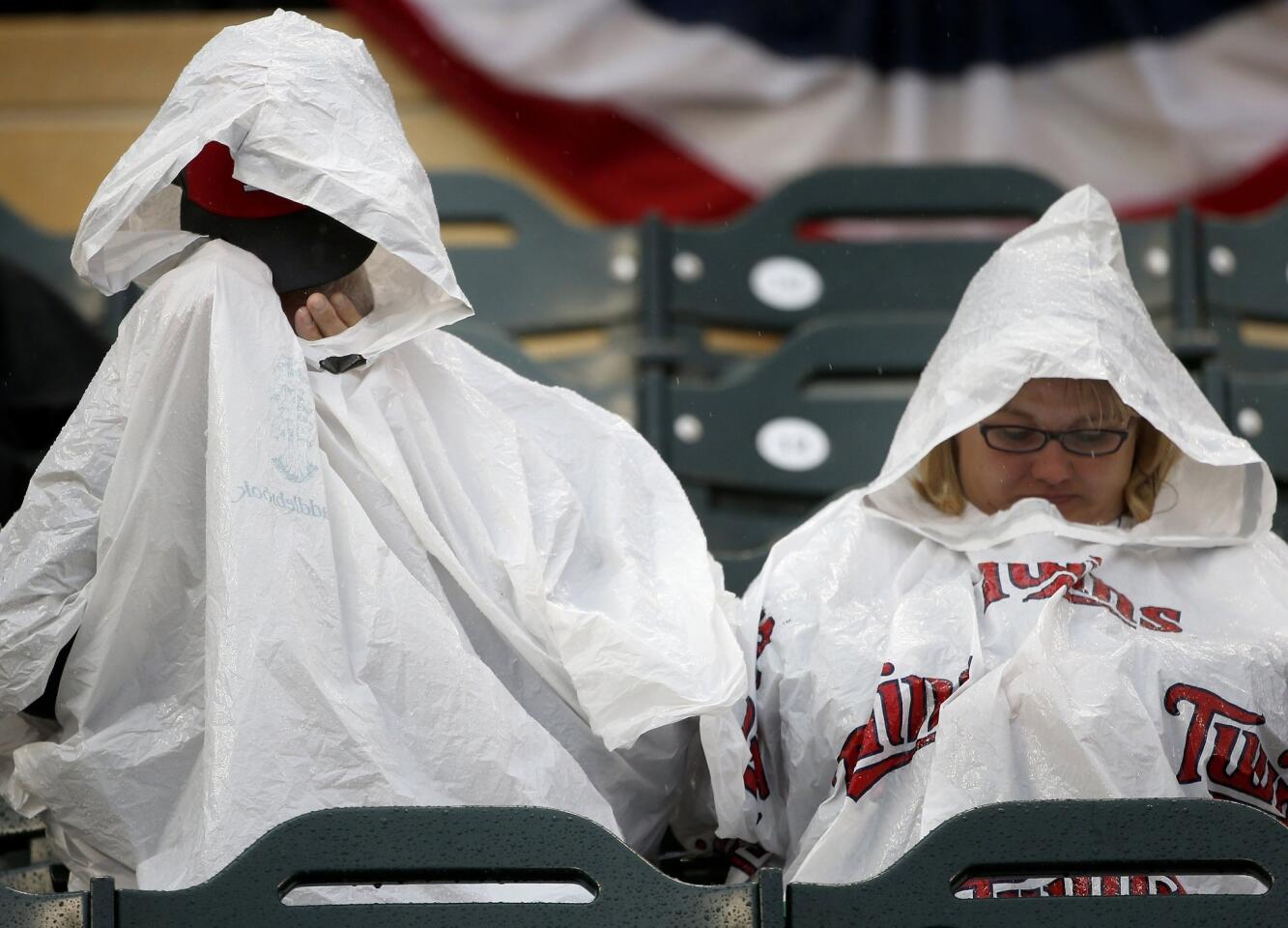 Fans huddled under ponchos in the stands at Target Field as rain delayed the start of the Home Run Derby 54 minutes on Monday.