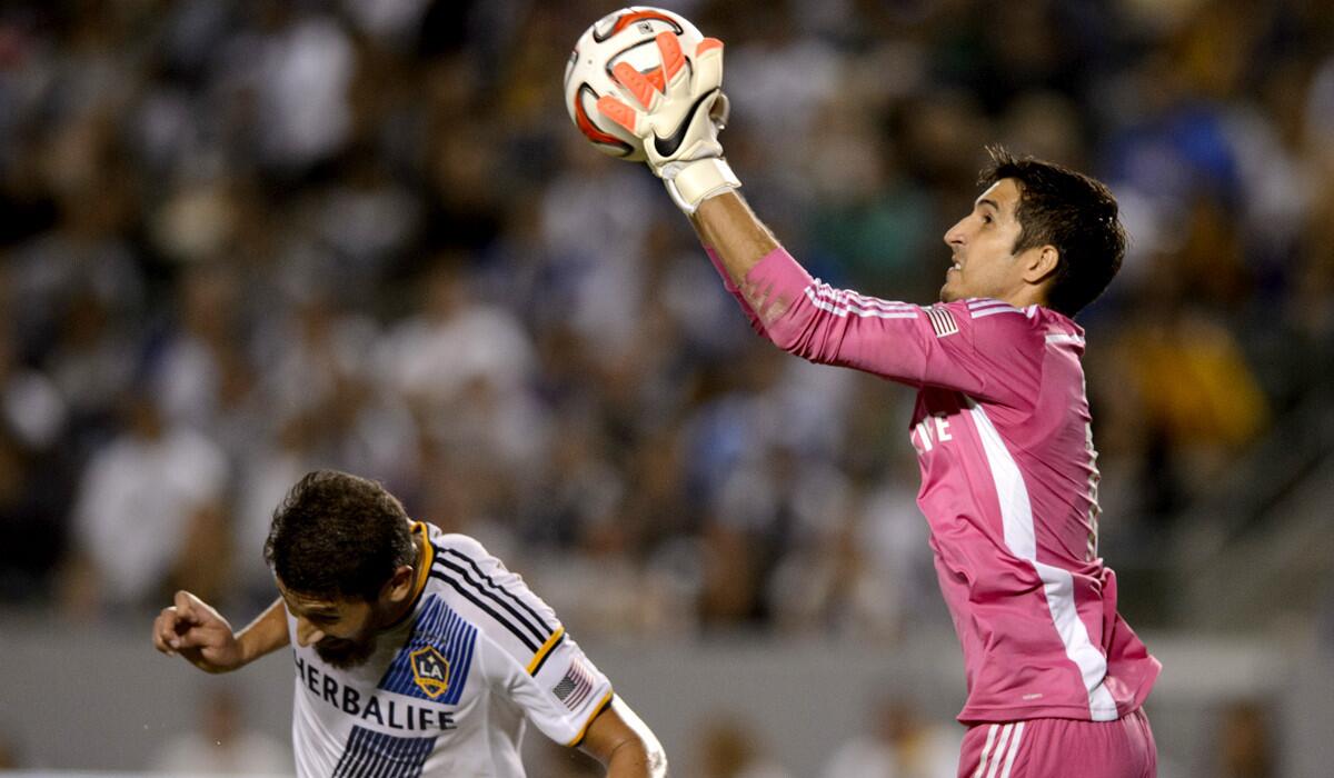 Galaxy goalie Jaime Penedo makes a save as defender Omar Gonzalez ducks out of the way during a game against the Seattle Sounders last month at StubHub Center.