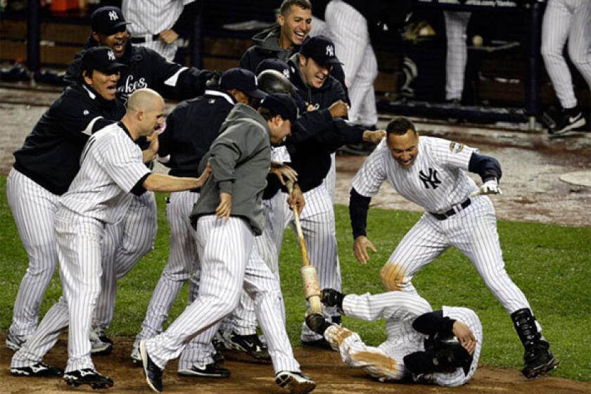 Yankees swarm Jerry Hairston Jr. after he scored the winning run beating the Angels, 4-3, in the 13th inning of Game 2 of the ALCS on Saturday night at Yankee Stadium.