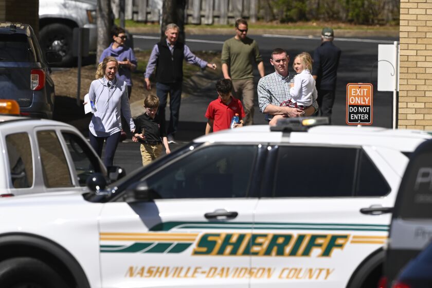 Familias salen de un lugar de reunión con sus hijos en Nashville, Tennessee, 27 de marzo de 2023, después de un tiroteo que mató a varios niños en la escuela Covenant de Nashville. El sospechoso murió en un enfrentamiento con la policía. (AP Foto/John Amis)