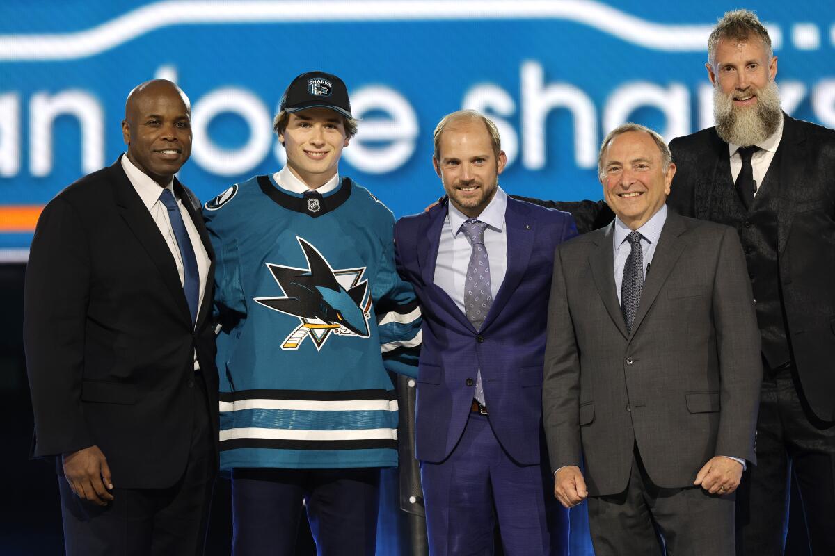 Macklin Celebrini, second from left, poses on stage after being selected first overall by the San Jose Sharks.