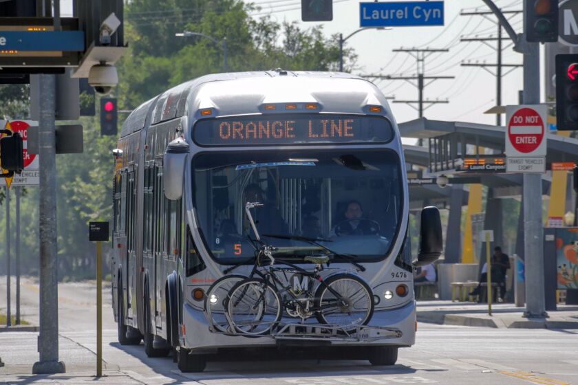 LOS ANGELES CA JULY 20, 2017 -- Metro Orange Line bus going through North Hollywood station. The first electric buses Metro buys will only run along the Orange Line busway in the San Fernando Valley and in the carpool lanes along the Harbor and El Monte freeways, officials say. Both routes will be retrofitted with charging stations where buses can âtop offâ if they run low on power. (Irfan Khan / Los Angeles Times)