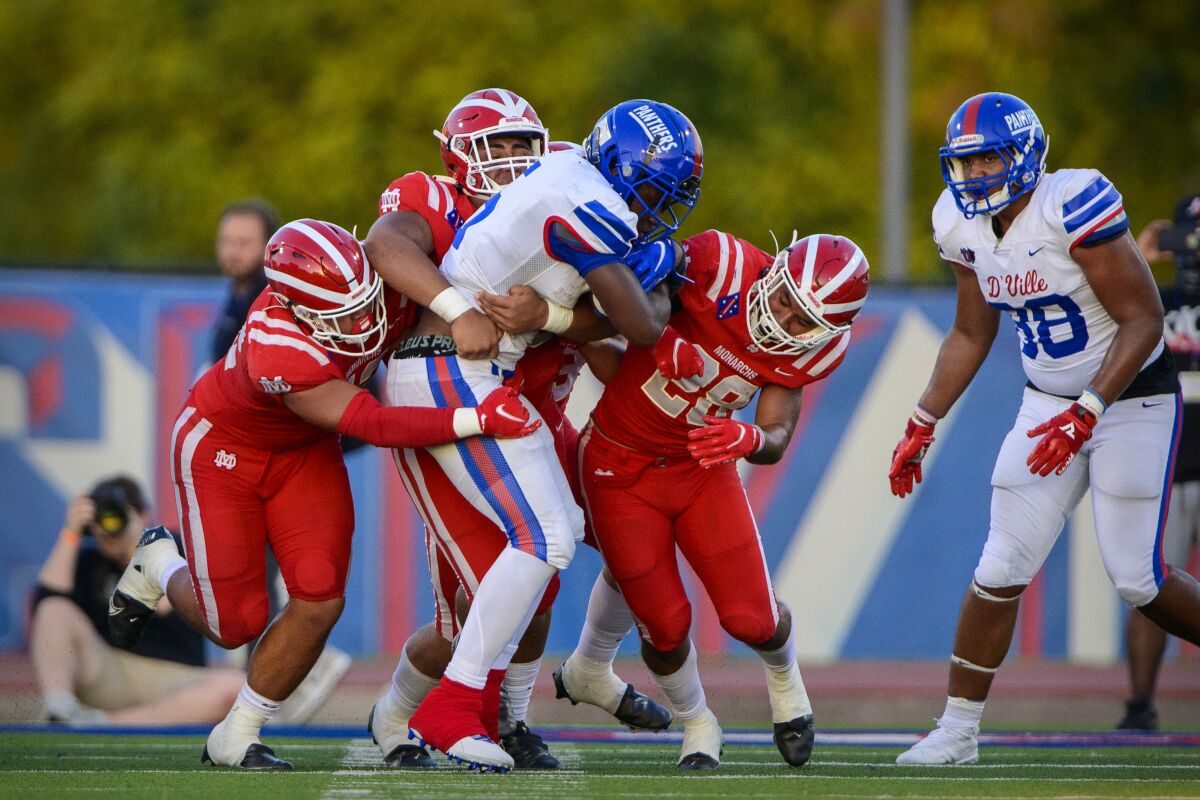 Duncanville running back Malachi Medlock is tackled for a loss by Mater Dei defenders.