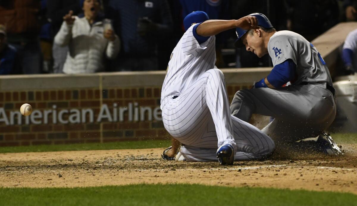 Chase Utley slides home past Cubs reliever Hector Rondon as he scores from first base on a throwing error.